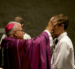 Pictured. A Bishop placing ashes on the head of a penitent on Ash Wednesday